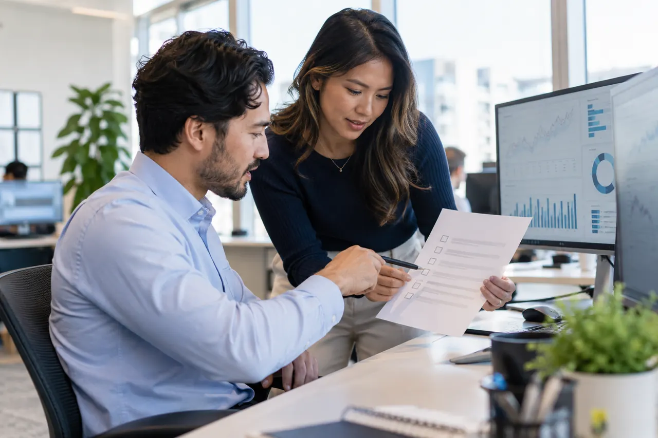 Brokerage team reviewing a compliance checklist next to currency charts