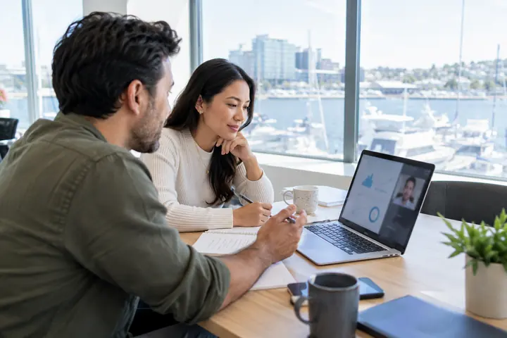 Team on a video call planning a client's email infrastructure in a glass meeting room